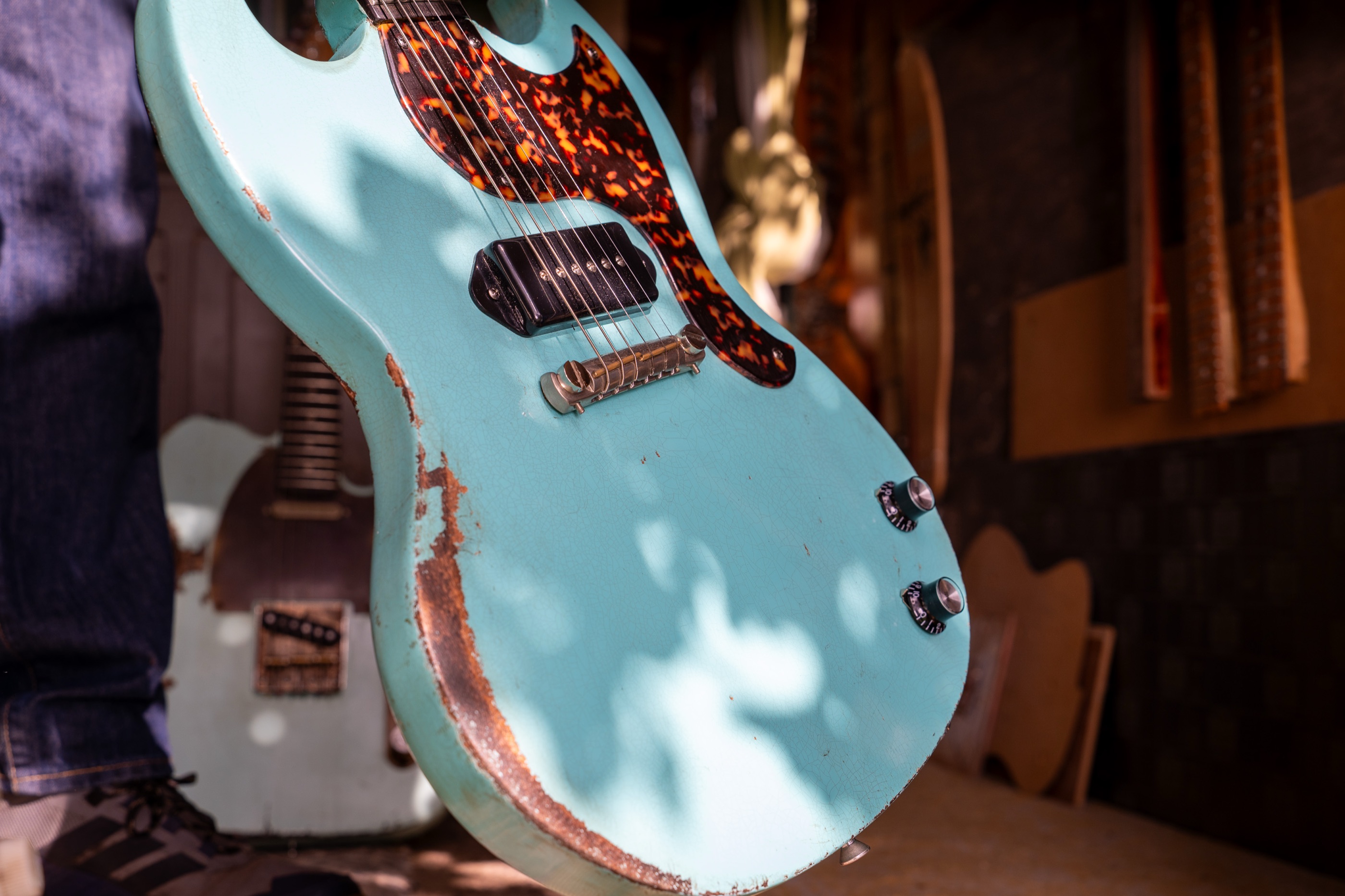 The Kid, a sonic blue SG Junior, held up in the shed, with the Gent and the Rebel behind it