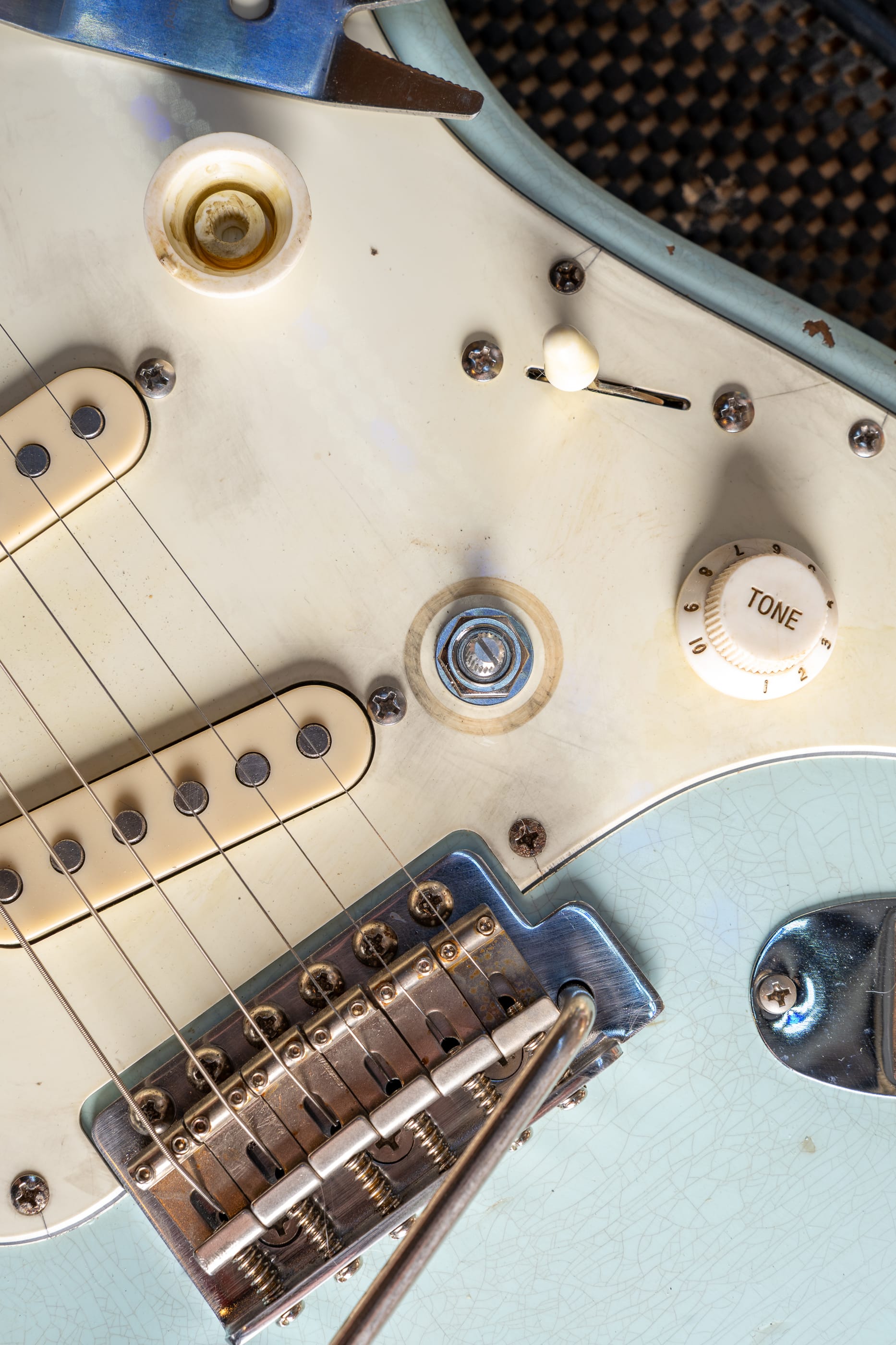 Echo's aged white guard, close: the crazing, the tone knob, the dirt in the screw heads